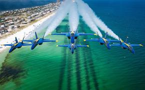Six airplanes fly in formation over a beach