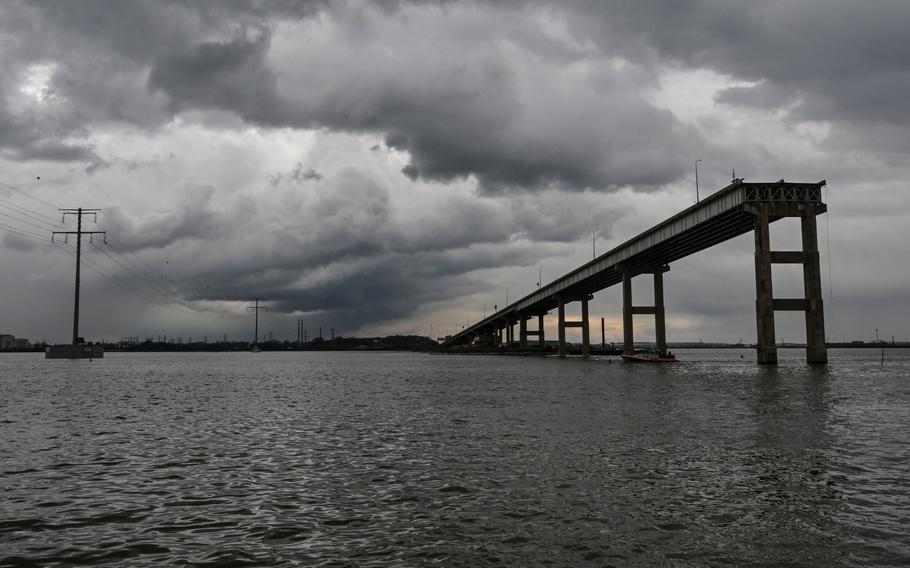 A section of the Francis Scott Key Bridge stands intact as workers dismantle the collapsed portion of it on April 4 in Baltimore.  