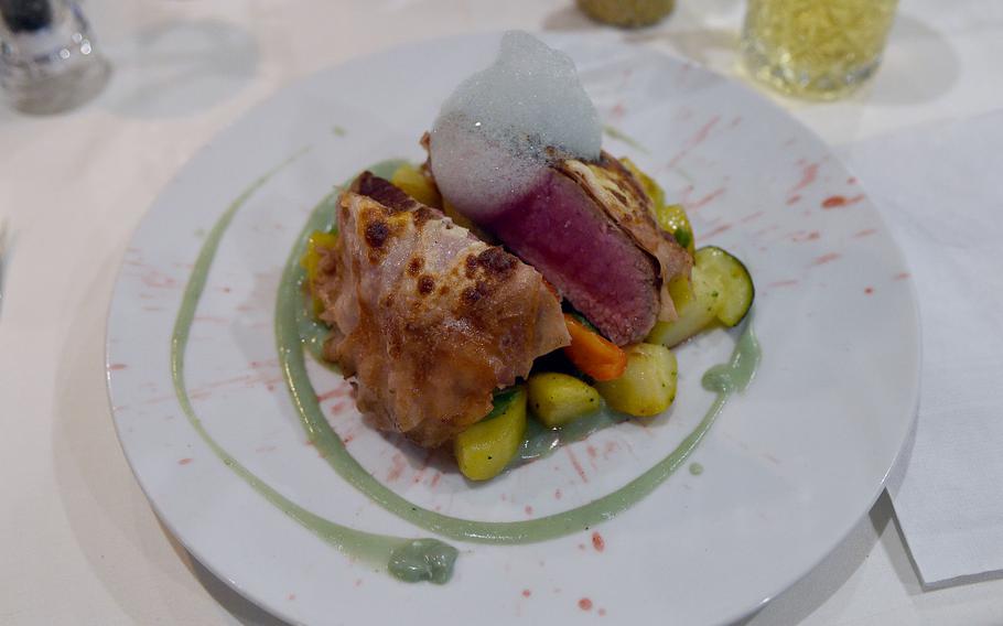 A filet mignon steak covered in Parma ham with vegetables
