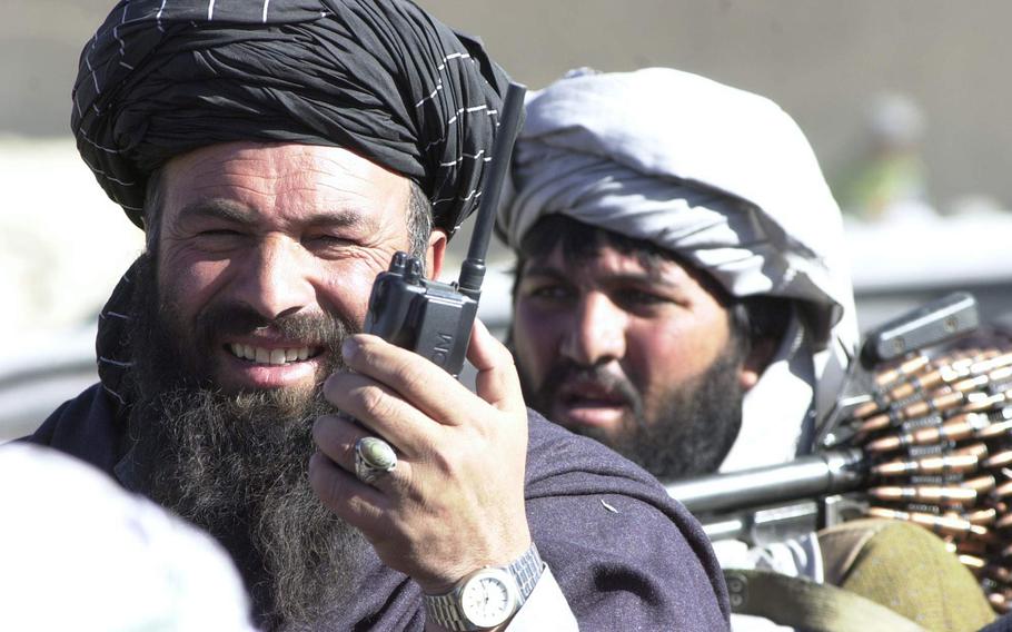 Haji Ghul Mohammed, commander of a group of Taliban soldiers just south of Kabul, makes the final coordination for the surrender of his forces Sunday morning, Nov. 25, 2001.