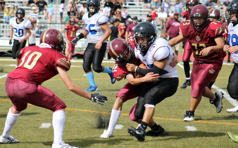 Osan's Eddie Kim is wrapped up by Matthew C. Perry's Austin LeMaster. Kim rushed for 246 yards and three touchdowns for the Cougars.