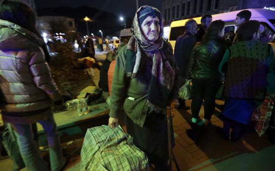 An ethnic Armenian woman from Nagorno-Karabakh carries her suitcase to a tent camp after arriving to Armenia's Goris in Syunik region, Armenia, late Friday, Sept. 29, 2023. Armenian officials say that by Friday evening over 97,700 people had left Nagorno-Karabakh. The region's population was around 120,000 before the exodus began. (AP Photo/Vasily Krestyaninov)
