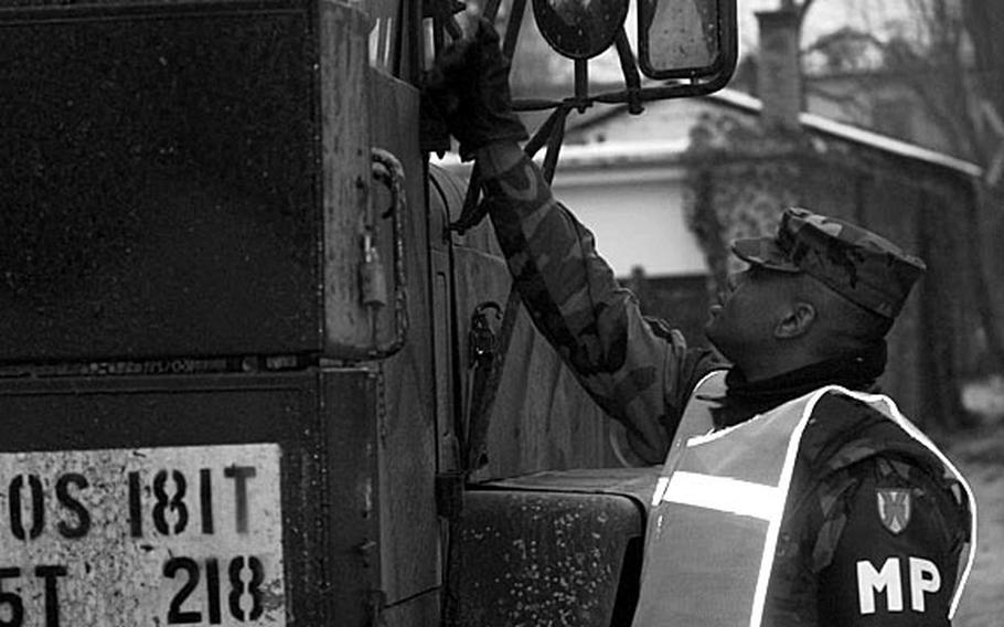 Taszar AB, Hungary, January, 1996: A soldier checks for proper identification for traffic entering and leaving Taszar AB.