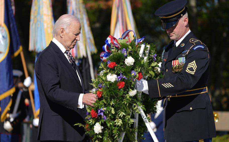 President Joe Biden, left, lays a wreath during a ceremony at the Tomb of the Unknown Soldier 