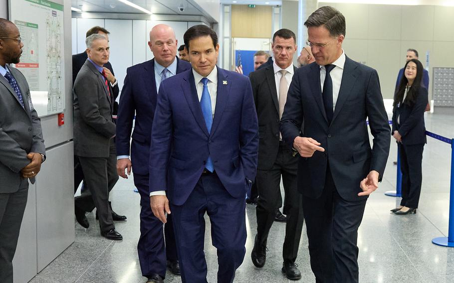 Marco Rubio and Mark Rutte, followed by officials wearing suits, walk through NATO’s headquarters. 