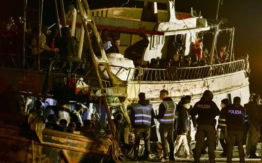 Police check a fishing boat with some 500 migrants in the southern Italian port of Crotone, early Saturday, March 11, 2023. The Italian coast guard was responding to three smugglers boats carrying more than 1,300 migrants “in danger” off Italy’s southern coast, officials said Friday. 