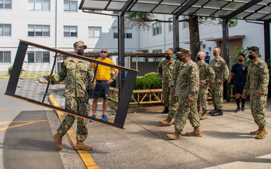 Sailors attached to Naval Air Facility Atsugi in August 2021 unload bed frames to be placed inside an unaccompanied housing building at the installation as part of a building revitalization project.