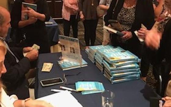 Lisa Molinari signs books at a recent author appearance in Virginia.