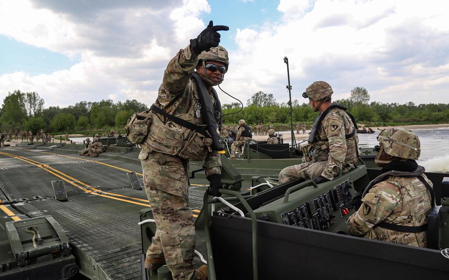 U.S. soldiers with the 1st Battalion, 66th Armored Regiment, 3rd Armored Brigade Combat Team, 4th Infantry Division, get a tank across the river on the ribbon bridge during a wet gap crossing during Defender Europe 2022 at Dęblin, Poland, May 12, 2022.