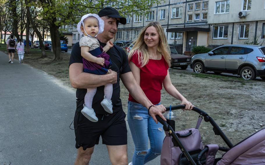 Kozachok holds his daughter Isabella while taking a walk with his wife, Yulia Bespala, in Kyiv on April 10, 2024.