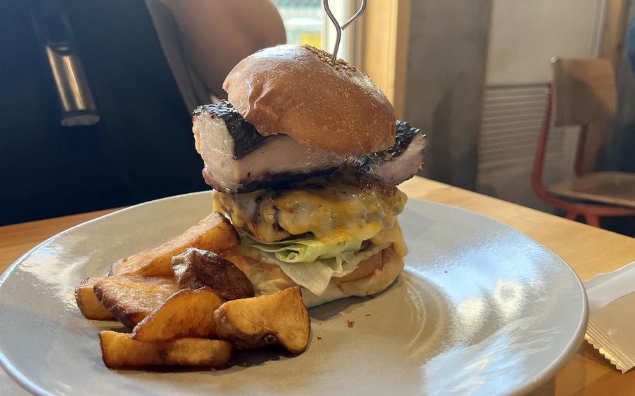 A stacked-high burger comes with a side of wedge-cut fries.