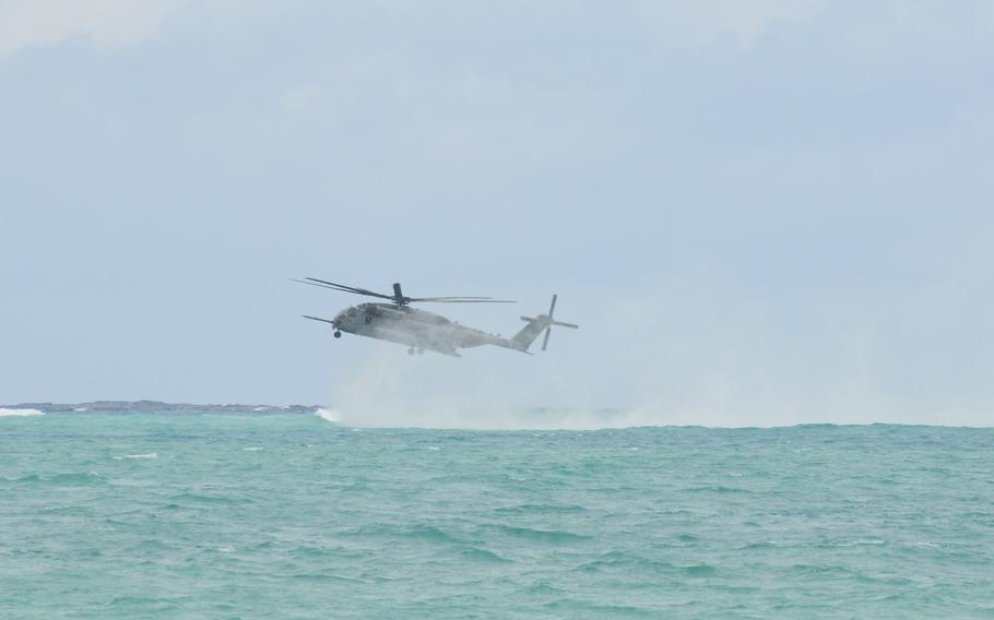 A Marine Corps CH-53E Super Stallion helicopter creates a vapor cloud as it hovers over waters just off Bellows Air Force Base, Hawaii, July 18, 2022, during helocasting training.