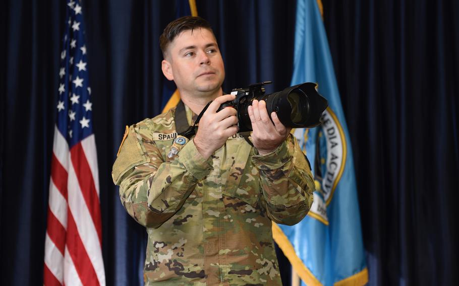 A soldier holding a camera.