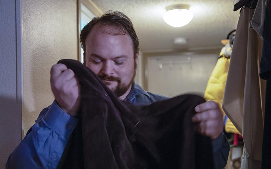John Holcombe smells a robe worn by his wife, Crystal Holcombe, who was killed in the shooting at their church in Sutherland Springs, Tex., in 2017. 