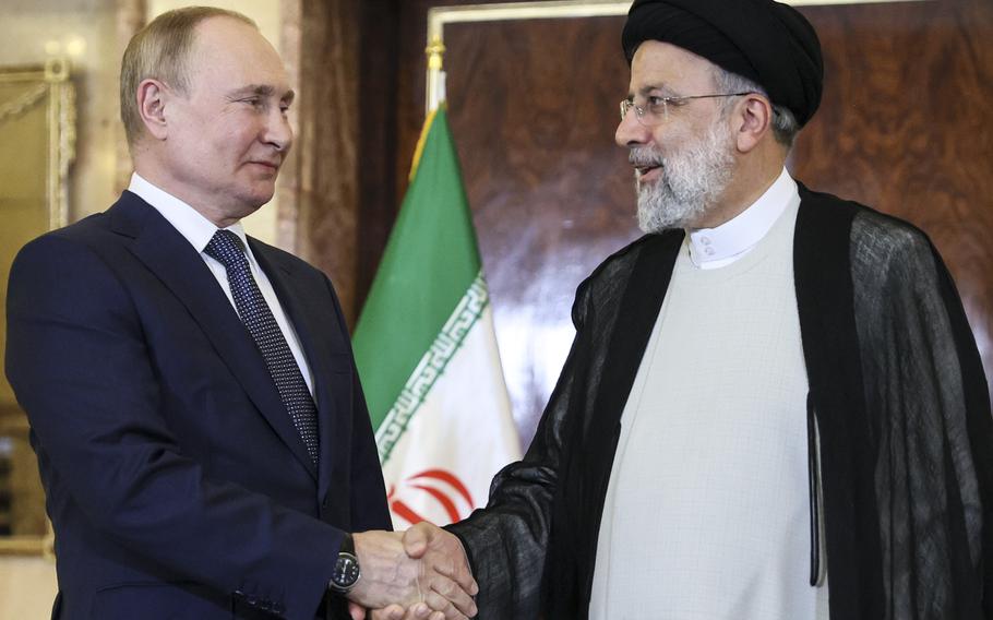 Russian President Vladimir Putin, left, shakes hands with Iranian President Ebrahim Raisi prior to their talks at the Saadabad palace, in Tehran, Iran, Iran, Tuesday, July 19, 2022. 