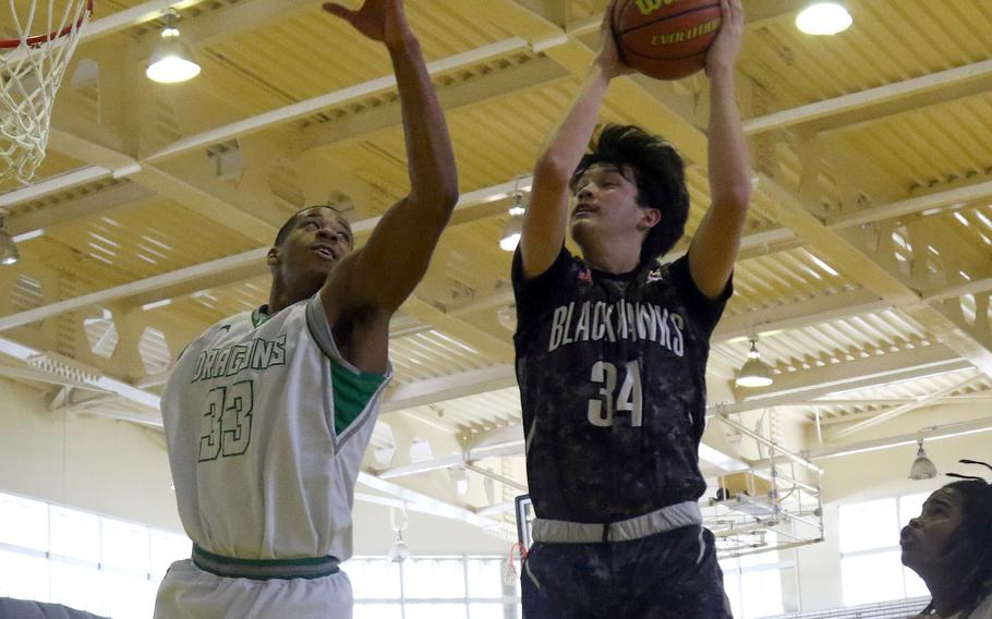 Humphreys' Validus Lauzon snags a rebound against Kubasaki's T.J. Reese during Monday's Far East Boys Division I pool-play game, won by the Dragons 59-43.