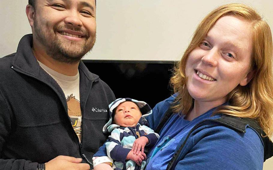 Petty Officer 2nd Class Dean Cates, a radio and video production supervisor for American Forces Network at Yokota Air Base in western Tokyo, and Petty Officer 2nd Class Aimee Ford, who works in public affairs for Naval Air Force Atlantic in Norfolk, Va., pose with their son, Lucas, in Virginia Beach in January 2023.