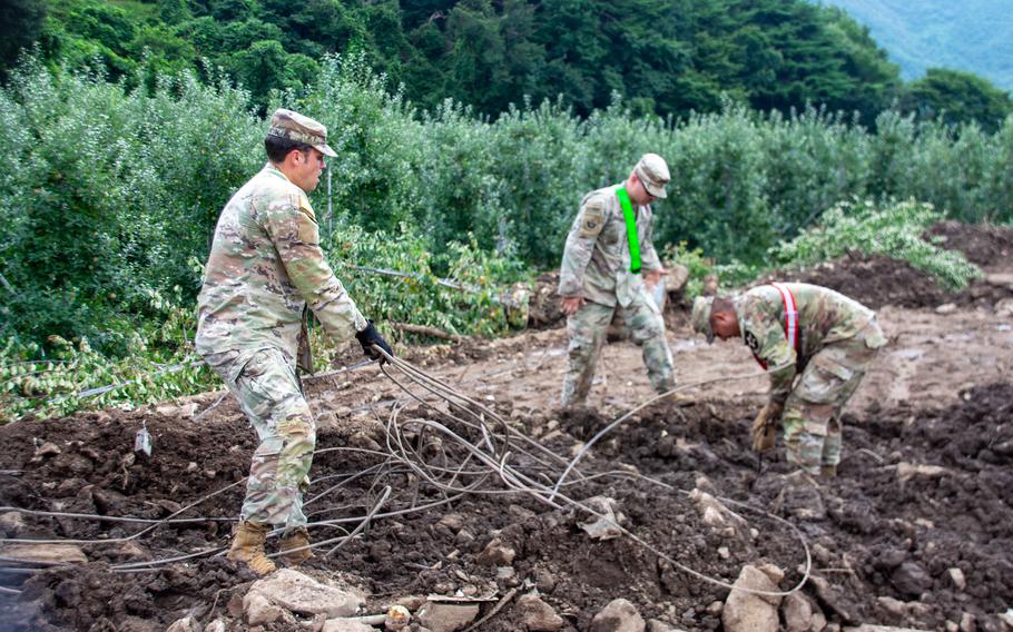 Soldiers of the 11th Engineer Battalion, 2nd Infantry Division clean up debris in the wake of recent fatal flooding and landslides in Yecheon county, South Korea, July 27, 2023. 