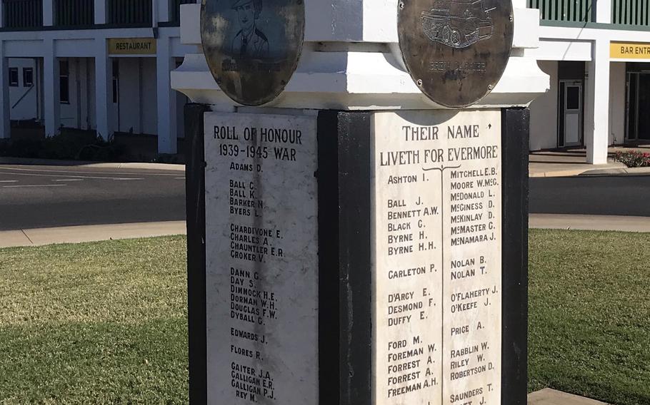 A war memorial monument with bronze medallions mounted on a white concrete pillar. The memorial displays a “Roll of Honour 1939-1945 War” with multiple columns of names listed under “Their Name Liveth For Evermore.” 