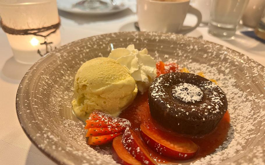 A small hot chocolate cake with vanilla ice cream and fresh fruit at Zur Pfaffschenke in Kaiserslautern, Germany. The restaurant also offers a limited selection of vegan ice cream.
