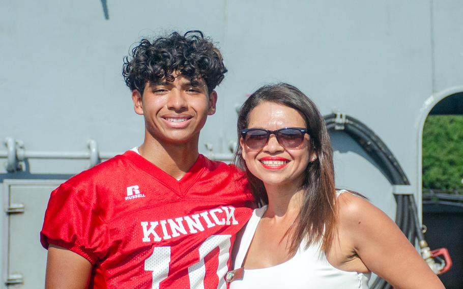 A member of the Nile C. Kinnick High School football team poses with his mother aboard the aircraft carrier USS Ronald Reagan at Yokosuka Naval Base, Japan, Tuesday, Sept. 12, 2023.