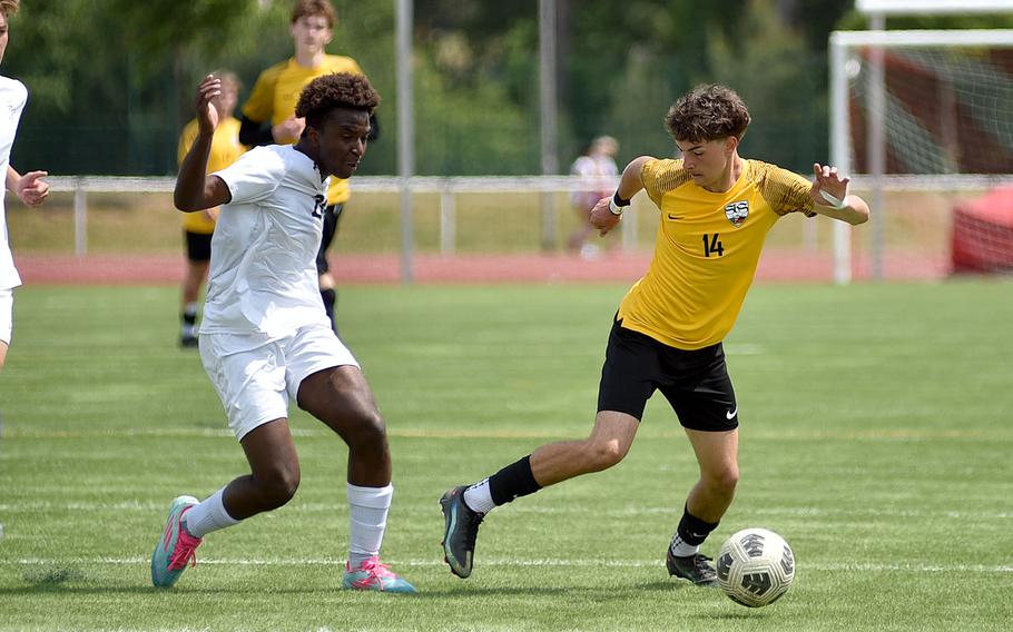 Stuttgart attacking midfielder Dom Tondre dribbles past Lakenheath midfielder Jonas Ballesteros-Burkett during a Division I semifinal match at the 2025 DODEA European championships on May 21, 2025, at Kaiserslautern High School in Kaiserslautern, Germany.