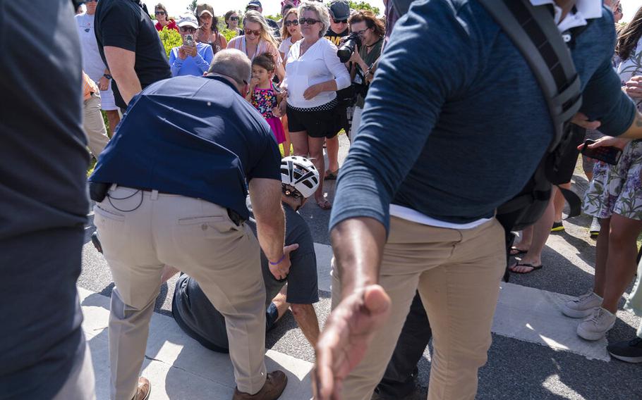 President Joe Biden is helped by U.S. Secret Service agents after he fell trying to get off his bike to greet a crowd on a trail at Gordons Pond in Rehoboth Beach, Del., Saturday, June 18, 2022. (AP Photo/Manuel Balce Ceneta)