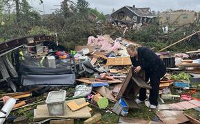 Theresa Haske sorts through debris from what was her garage after a tornado tore through Gaylord, Mich., Friday, May 20, 2022.