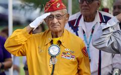Navajo Code Talker Thomas Begay salutes during the national anthem at the Arizona State Navajo Code Talkers Day celebration, Sunday, Aug. 14, 2022, in Phoenix. (AP Photo/Ross D. Franklin)
