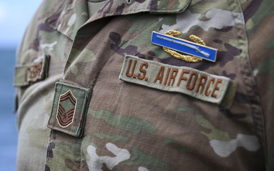 Close-up detail of a U.S. Air Force uniform showing military insignia and patches. 