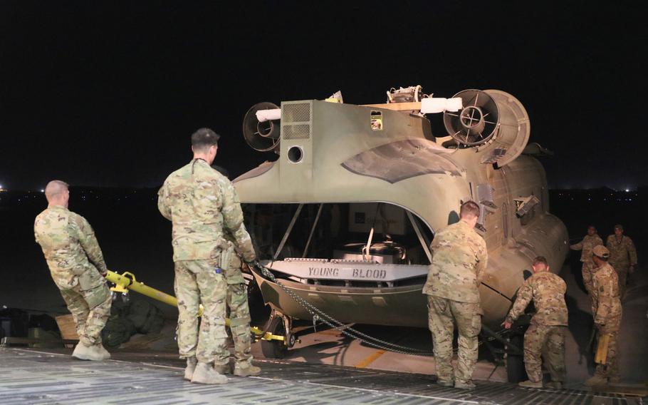 Aerial porters work with maintainers to load a CH-47 Chinook into a C-17 Globemaster III during the drawdown of troops and equipment in Afghanistan, June 16, 2021. The U.S. has completed more than 90% of its withdrawal from the country, a U.S. Central Command statement said July 6, 2021.