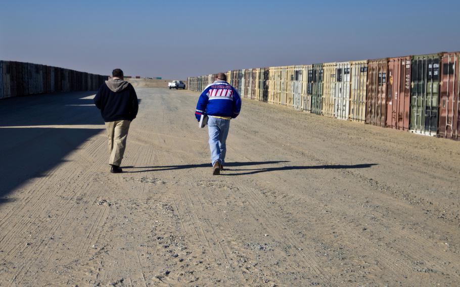 Personnel walk past rows of containers at Camp Arifjan, Kuwait, in 2017. The Army didn’t properly account for millions of dollars in government property provided to a base operations and security support contractor in Kuwait, the Defense Department Inspector General said in a report released June 27, 2022.