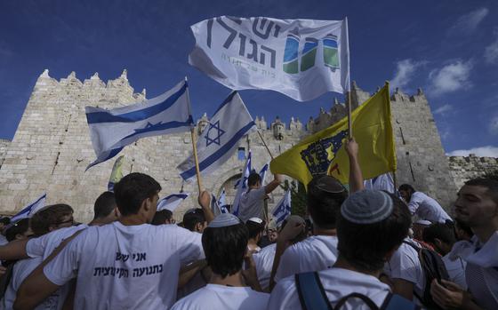 Israelis wave national flags during a march marking Jerusalem Day, an Israeli holiday celebrating the capture of east Jerusalem in the 1967 Mideast war, in front of the Damascus Gate of Jerusalem's Old City, Thursday, May 18, 2023. (AP Photo/Mahmoud Illean)
