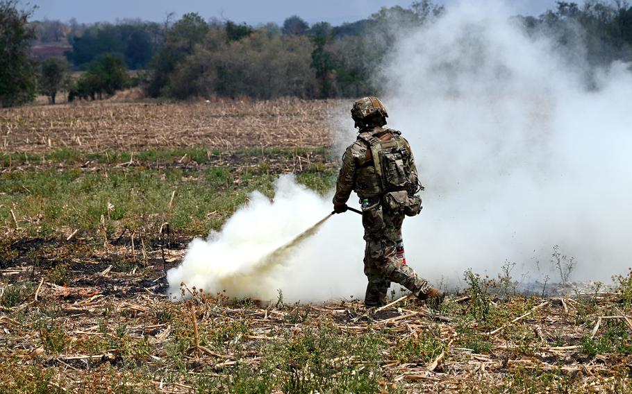 A soldier uses a fire extinguisher to put out a small fire. 
