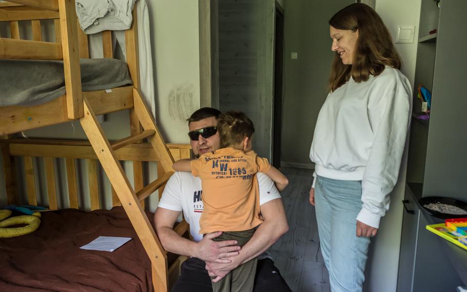Abdulin hugs his 9-year-old son Vadym at home in Bila Tserkva as his wife, Olesia Abdulina, stands watching.