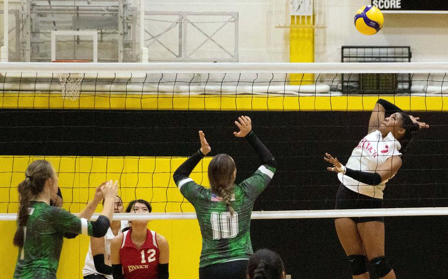 Nile C. Kinnick's Michele Hollway prepares a spike against Kubasaki's Isabella Garza and Jackie Mitchell.