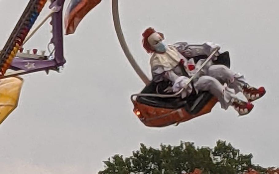 Someone dressed as Pennywise the Dancing Clown from the 2017 and 2019 adaptations of the Stephen King novel ''It'' enjoys a carnival ride Oct. 17, 2021, at the Barbarossaland fair in Kaiserslautern, Germany. Air Force Staff Sgt. Alexis Smith took the photo and sent it to alert her husband after the sight gave her chills, she told Stars and Stripes Oct. 22, 2021.