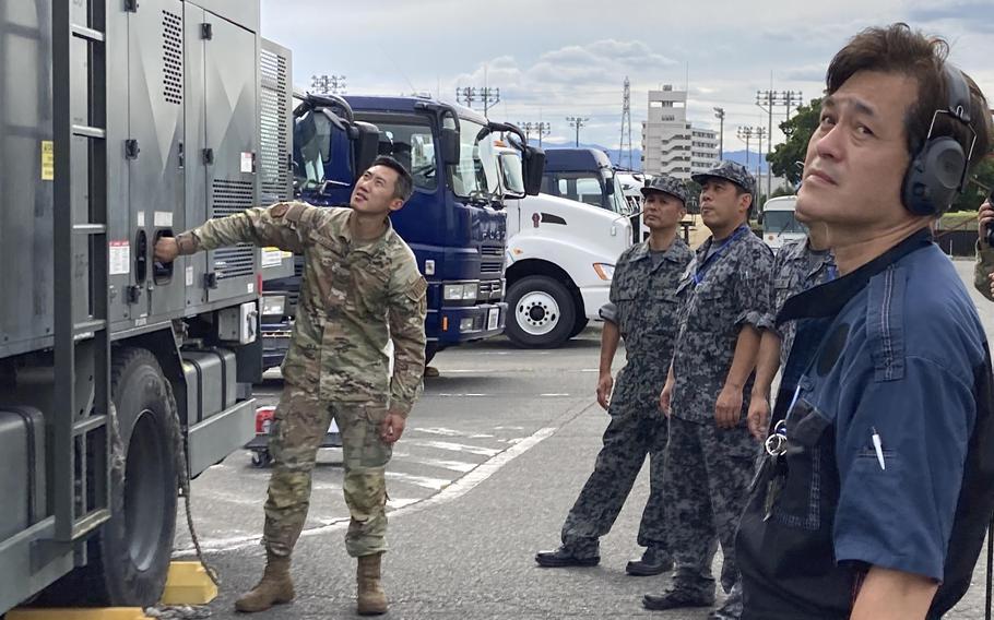 Air Force Staff Sgt. Kevin Saelor teaches Japanese airmen about the deicer used at Yokota Air Base, Japan, Thursday, Sept. 7, 2023. 