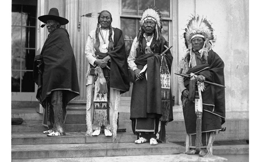 Four Cheyenne chiefs standing together wearing their traditional clothing.