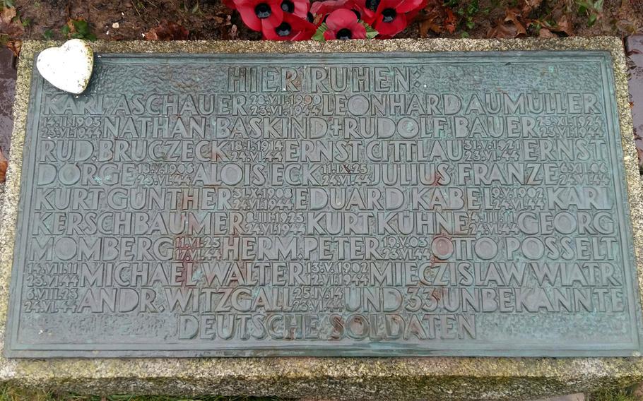 The name of U.S. Army 1st Lt. Nathan Baskind can be seen in the upper left corner of a tablet marking a mass grave at the Marigny German War Cemetery in Thereval, France.