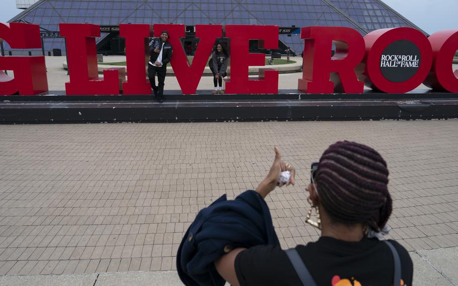 Carla Spears takes photos of her nephew, Anthony Hendricks and his daughter Promise Hendricks, 16, outside of the Rock & Roll Hall of Fame, the most famous attraction in Cleveland. 