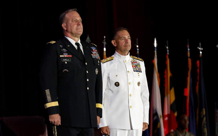 An outgoing general and incoming admiral stand at attention during their change of command. 
