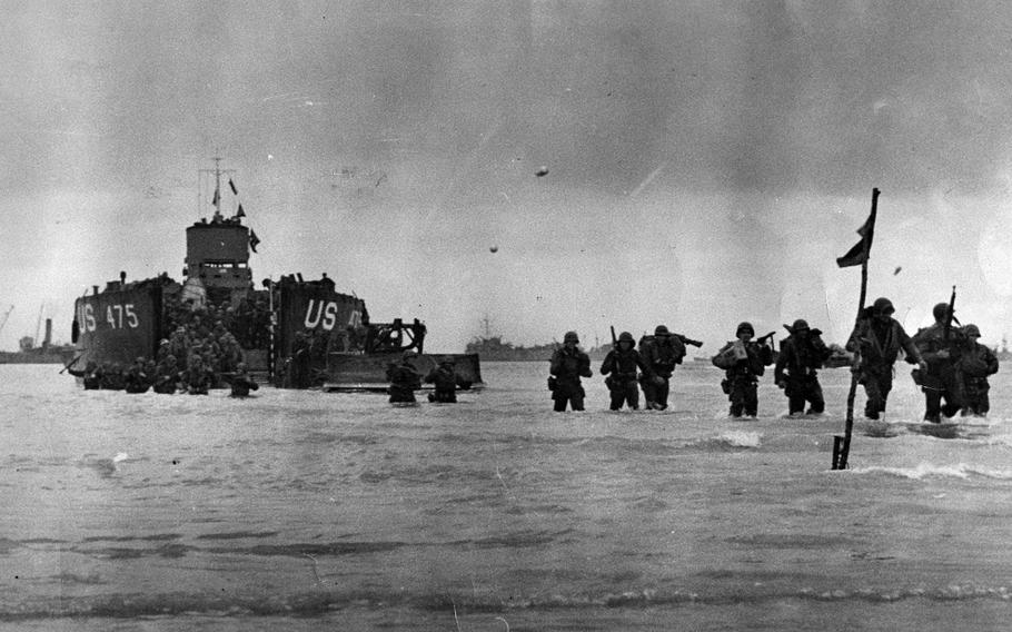 American troops wade through surf carrying their equipment at Utah Beach, June 7, 1944. Martin Marty Sylvester was one of the troops who landed at the beach that day. He is in Normandy with his son for the 80th anniversary of the D-Day landings.