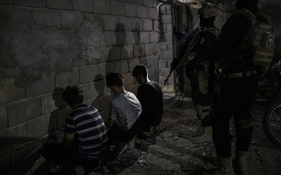 Special anti-drug forces inspect suspects during a nighttime operation in Basra on Aug. 18.