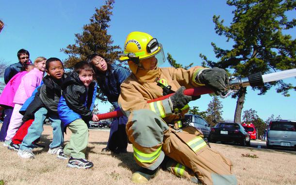 Camp Zama, Japan, Feb. 23, 2005: School children at the John O. Arnn Elementary School get an opportunity to handle a fire hose with the Sagamihara City Fire Department.

META TAGS: military family; military community; children; DODEA; military child;