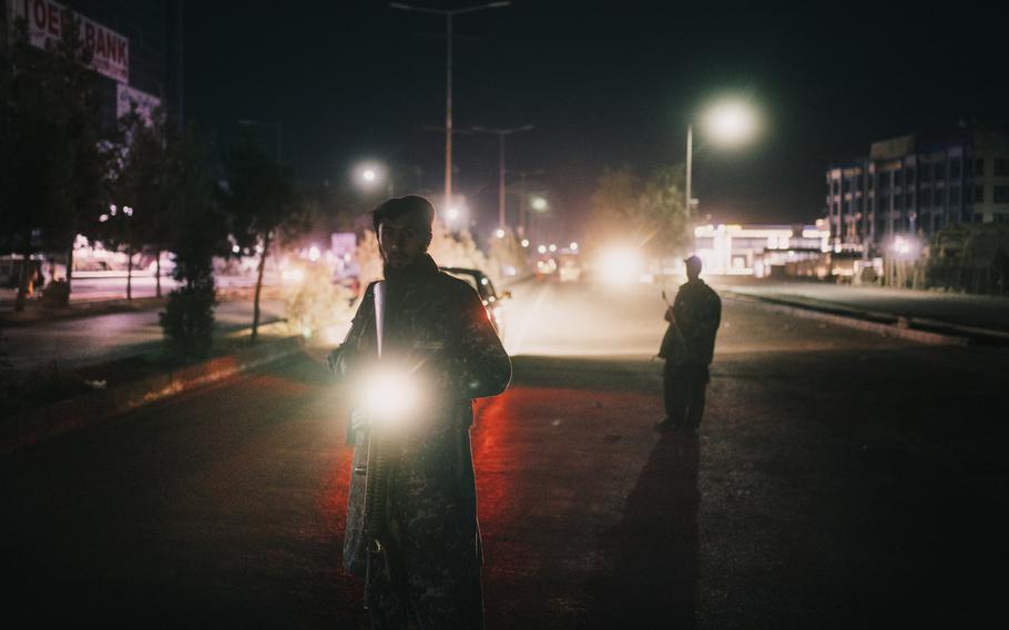 Taliban militants stop and check cars in eastern Kabul on Oct. 5, 2021. 