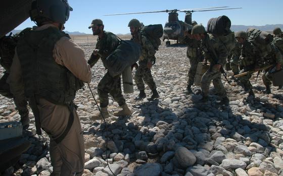 Deh Rawood, Afghanistan, March 24, 2004: Staff Sgt. Robert Kilcup watches as Afghan National Army soldiers load on one of his unit's CH-47D Chinook helicopters in Deh Rawood, Afghanistan. Two Chinooks flew out Humvees to the base, then returned with the Afghan army soldiers. Kilcup's unit, the Nomads of Company G, 104th Aviation Regiment has flown more than 25,000 passengers, ranging from video camera-toting reporters to rocket propelled grenade-carrying Afghan National Army soldiers. The unit comprised of nearly 200 Connecticut and Pennsylvania National Guard. 

Read the full story and see additional images here. https://www.stripes.com/news/squadron-conquers-afghan-weather-terrain-1.18156 

META TAGS: Operation Iraqi Freedom; Operation Enduring Freedom; Afghanistan; War on Terror; National Guard; U.S. Army; 