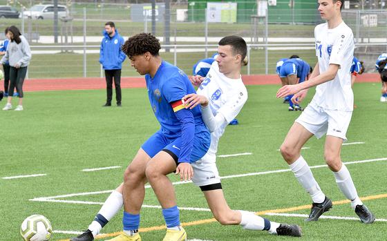 Ramstein captain Max Speed tries to hold off Wiesbaden's Ante Dugandzic near the endline during Saturday's match at Ramstein High School on Ramstein Air Base, Germany. Coming to help is Warrior midfielder Robbie Dugandzic.