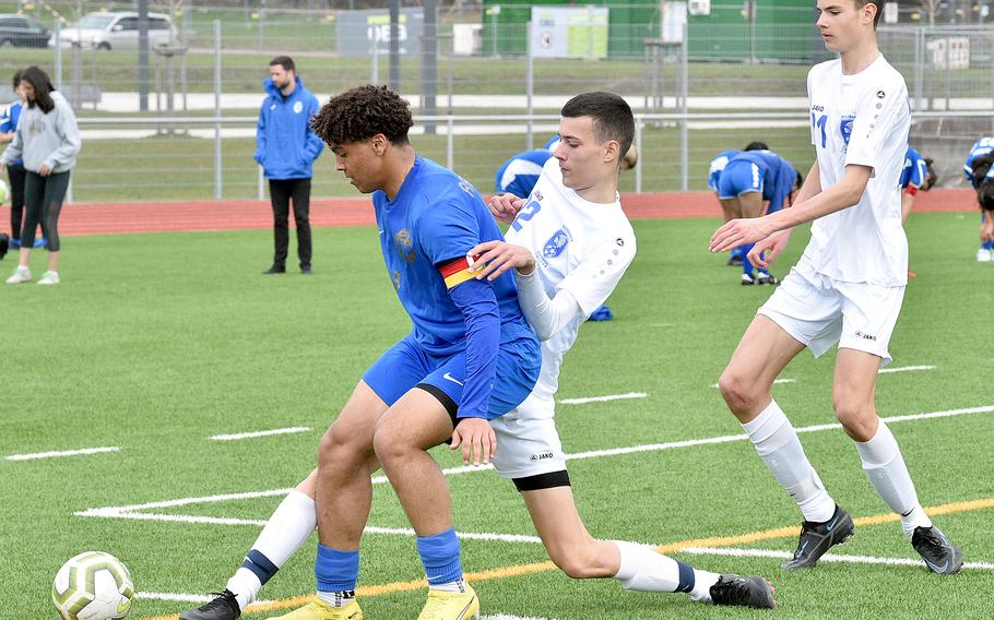 Ramstein captain Maxim Speed tries to hold off Wiesbaden’s Ante Dugandzic near the end line during Saturday’s match at Ramstein High School on Ramstein Air Base, Germany. Coming to help is Warrior midfielder Robbie Dugandzic.