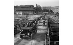 [PUBLISHED CAPTION: A convoy speeds across the Rhine River on one of the several bridges. 10/07/1951]; Vehicles cross a pontoon bridge over the river Rhine on the second day of "Excercise Jupiter."  The three-day French directed war games have some 150,000 Allied troops - including 45,000 Americans of the Army's V Corps - enact a mass counterassault across the Rhine against "enemy" troops dug in on the east bank. [cg]